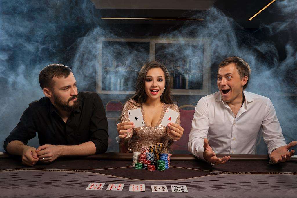 Group of a young rich friends are playing poker in casino.
